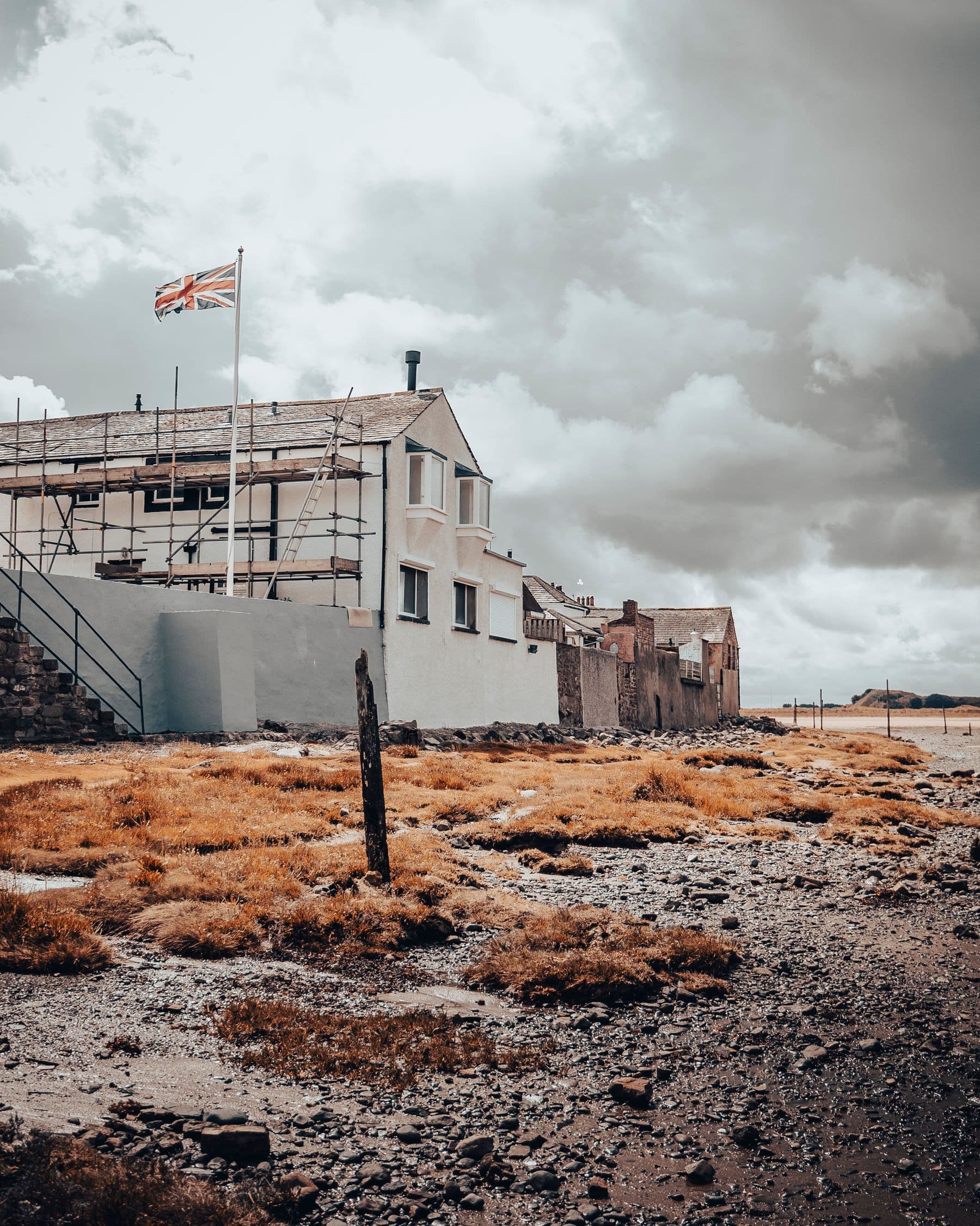 Scaffolding on a house under a stormy sky in the UK